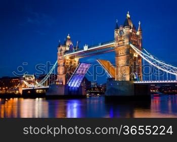 Tower Bridge in London, the UK at night. The bridge is opening