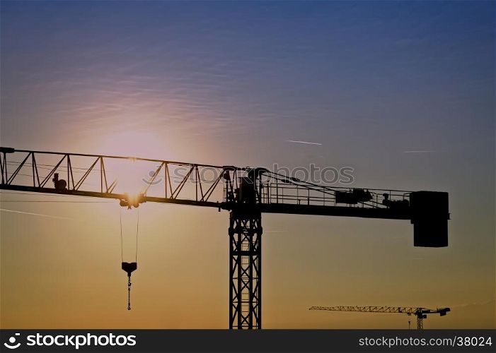 Tower crane on a construction site at sunrise
