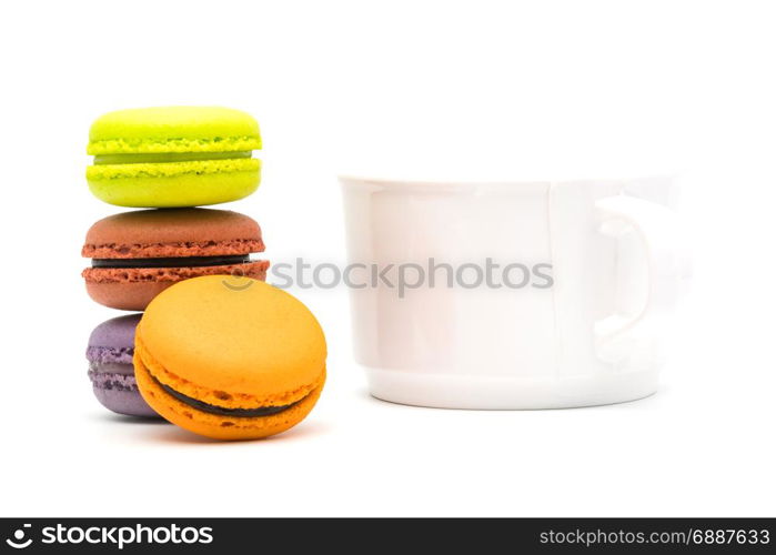 Tower of sweet macarons and a cup of hot tea on white background