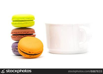 Tower of sweet macarons and a cup of hot tea on white background