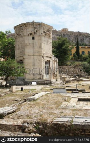 Tower of the Winds (Horologion or Aerides) in Athens, Greece. Built in 2nd century BC. It served as a compass, sundial, wetaher vane and water clock. Each face of the frieze is adorned with a relief of one of the god winds. Akropolis in the background. HDR.