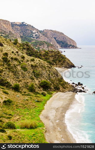 Tower on spanish coast, seaside cliffs of Maro Cerro Gordo. Costa del Sol, Andalusia Spain.. Tower on rocky coast, seaside cliffs, Spain