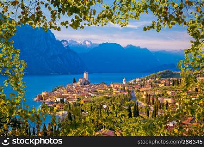 Town of Malcesine on Lago di Garda skyline view through leaves frame, Veneto region of Italy