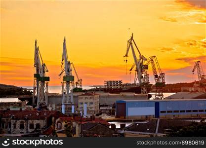 Town of Pula shipyard cranes sunset view, Istria region of Croatia