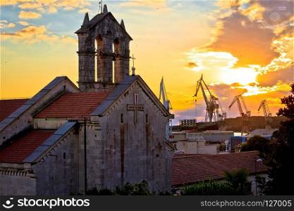 Town of Pula stone church and shipyard cranes sunset view, Istria region of Croatia