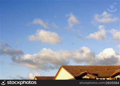 Townhouse rooftops against a blue sky