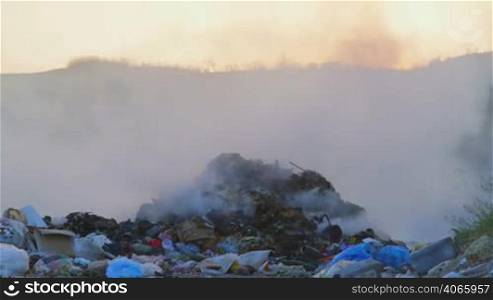 Toxic smoke from burning dump rises into the air pan shot