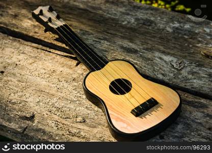 Toy acoustic guitar on vintage wood background, Close-up