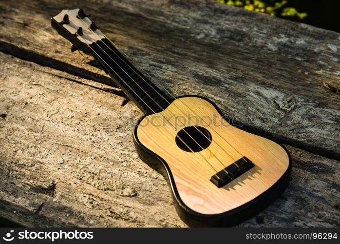 Toy acoustic guitar on vintage wood background, Close-up