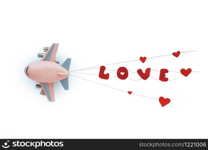 Toy airplane and the bright red word LOVE on the ropes behind. White background.
