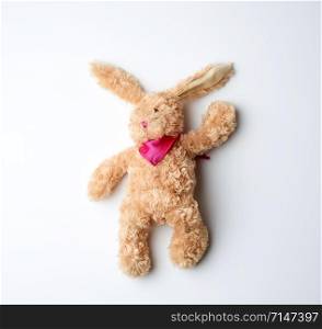 toy brown plush hare lies on a white background, top view