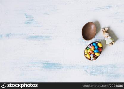 toy bunny near halves chocolate egg