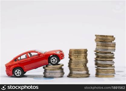 toy car going up increasing stack coins against white background. Resolution and high quality beautiful photo. toy car going up increasing stack coins against white background. High quality and resolution beautiful photo concept