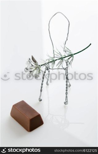 Toy chair with a flower and chocolate candy on a white background