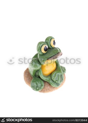 toy frog with a coin in his mouth on a white background