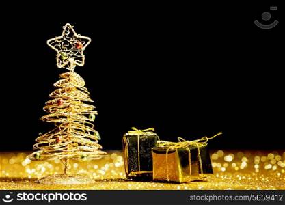 Toy golden decorative Christmas tree on glitter background
