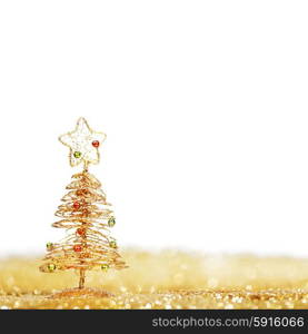 Toy golden decorative Christmas tree on glitter background