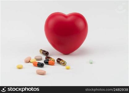 Toy heart with pills on white background. Concept healthcare. Cardiology - care of the heart. cardiology, heart care