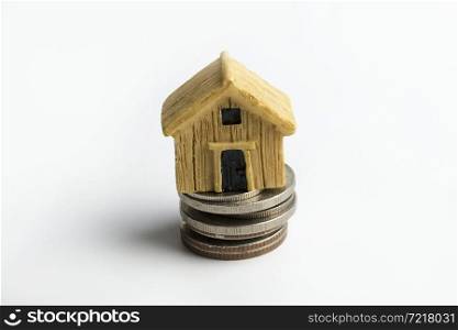 Toy house on coins on a white background.. Toy house on coins.