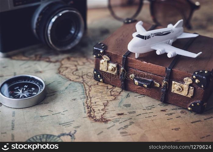 Toy plane and suitcase on vintage map with copy space, Travel concept