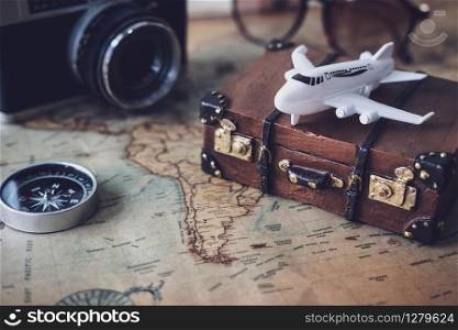 Toy plane and suitcase on vintage map with copy space, Travel concept