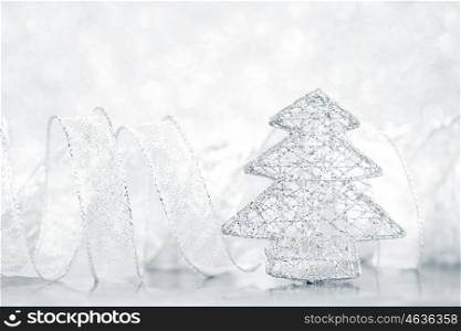 Toy silver decorative Christmas tree on glitter background