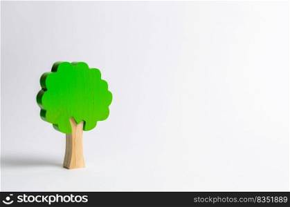 Toy wooden tree on a white background. Minimalism and the concept of environmental conservation. lungs of the planet. Family tree, a symbol of strength and wisdom. Illegal deforestation.