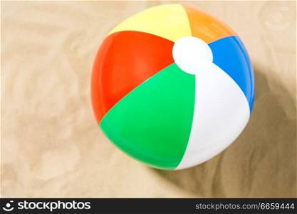toys and summer vacation concept - close up of inflatable beach ball on sand. close up of inflatable beach ball on sand