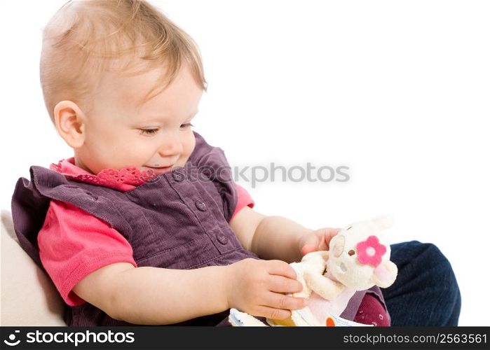 TOYS ARE PROPERTY RELEASED!!! Happy baby girl (9 months) playing with soft toy and smiling. Isolated on white.