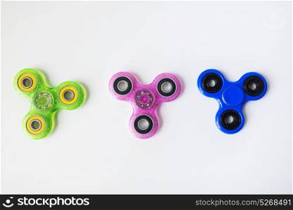 toys, entertainment and object - three fidget spinners on white background. three fidget spinners on white background
