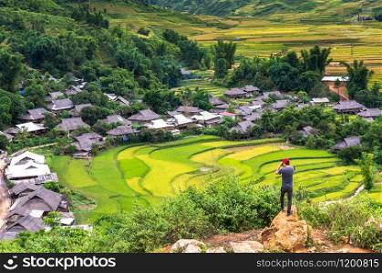 Traaveler take picture at Rice fields on terraced of Tu le District, YenBai province, Northwest Vietnam