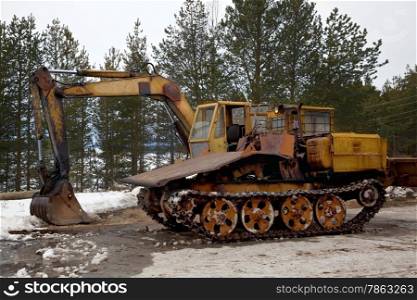 Tracked vehicles. Excavator and trelevochnik against the backdrop of a pine forest