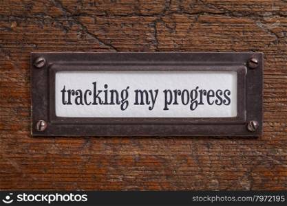 tracking my progress - a label on a grunge wooden file cabinet