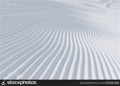 tracks on ski slopes in snow at beautiful sunny winter day with blue sky
