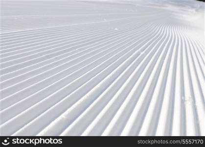 tracks on ski slopes in snow at beautiful sunny winter day with blue sky