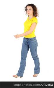 tractive woman in yellow shirt and jeans walking left isolated on white