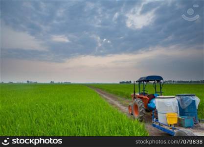 tractor in meadow green countryside on sunset