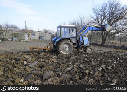 Tractor plowing the garden. Plowing the soil in the garden.. Tractor plowing the garden. Plowing the soil in the garden