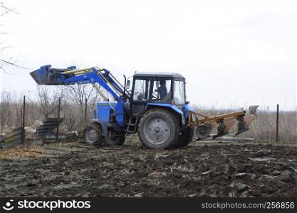 Tractor plowing the garden. Plowing the soil in the garden.. Tractor plowing the garden. Plowing the soil in the garden