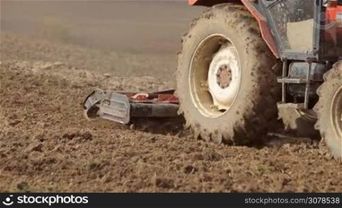 Tractor preparing land for sowing close shot