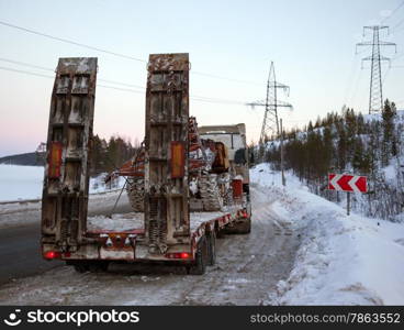 Tractor-trailer transports skidder for restoration works on power lines