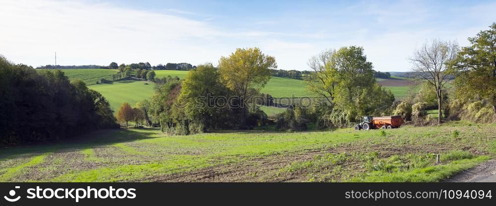 tractor with cart in agricultural landscape of south limburg in the autumn on sunny day