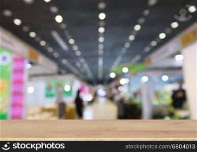 trade fair in exhibition hall, booth selling cheap goods from the manufacturer with selected focus wood table for display your product