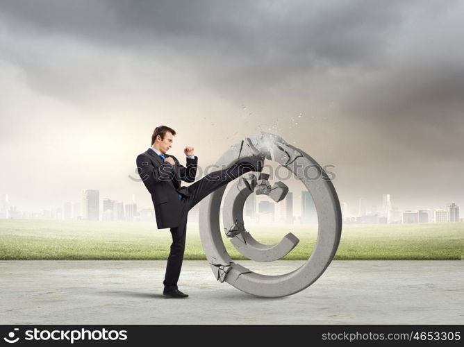 Trademark. Angry businessman crashing stone trademark with karate kick