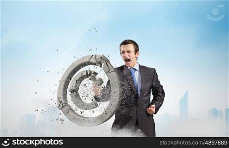 Trademark. Angry businessman crashing stone trademark with karate kick