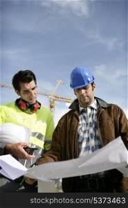Tradesman and an engineer examining a blueprint