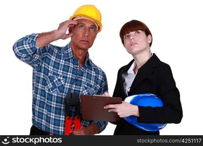Tradesman and engineer looking at the ceiling
