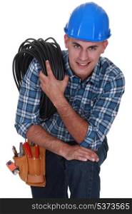 Tradesman carrying a cable coiled around his shoulder