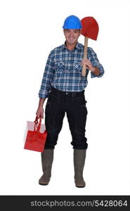 Tradesman carrying a spade and a toolbox