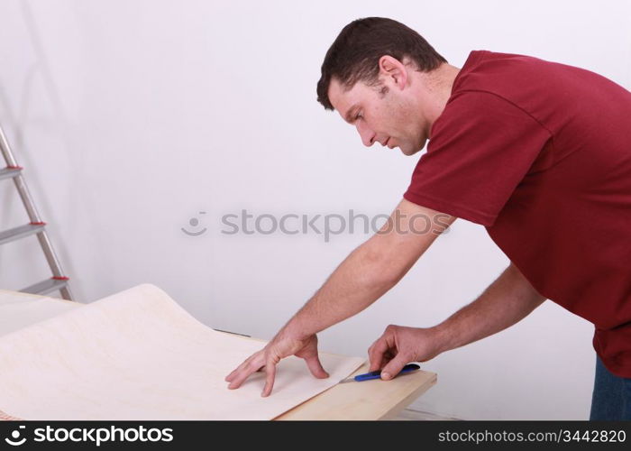 Tradesman cutting a sheet of paper